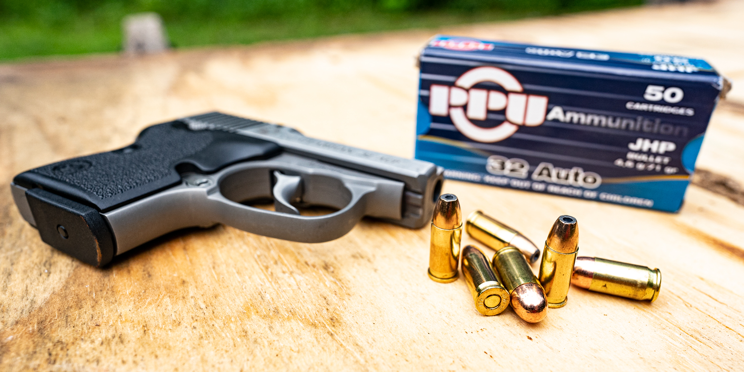 32 ACP ammo and pistol on a shooting bench