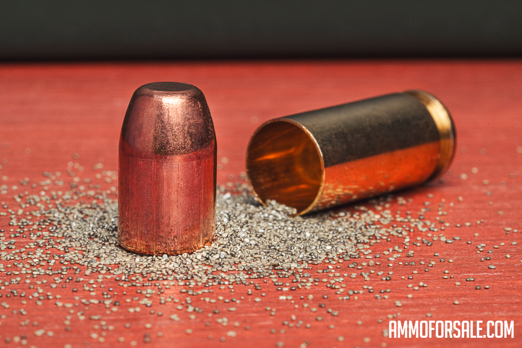 A pulled truncated cone bullet from a round of ammo displayed with brass casing and gun powder.