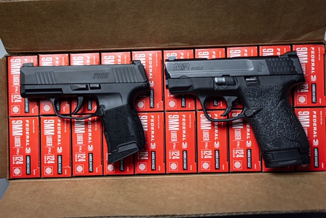 Sig P365 vs. S&W Shield 9mm pistols in an ammo box