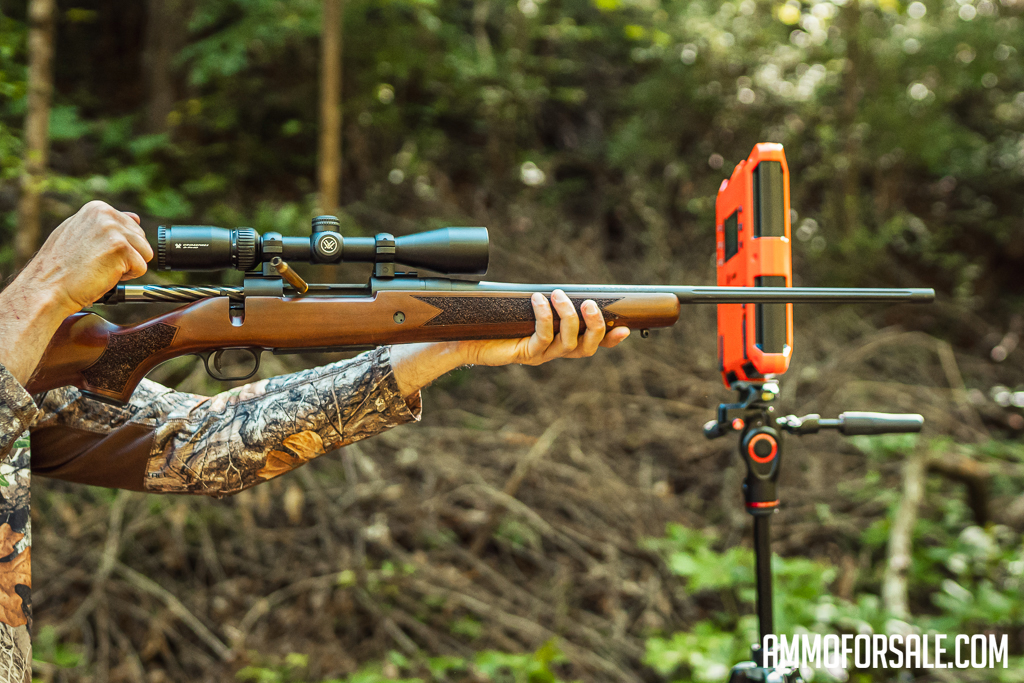 The author firing a 30-06 Mossberg rifle at the range with a chronograph