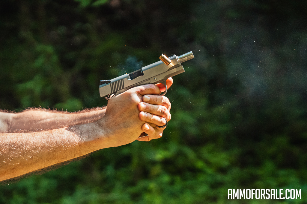 The author demonstrates the recoil of a 45 ACP load while shooting a handgun at the range