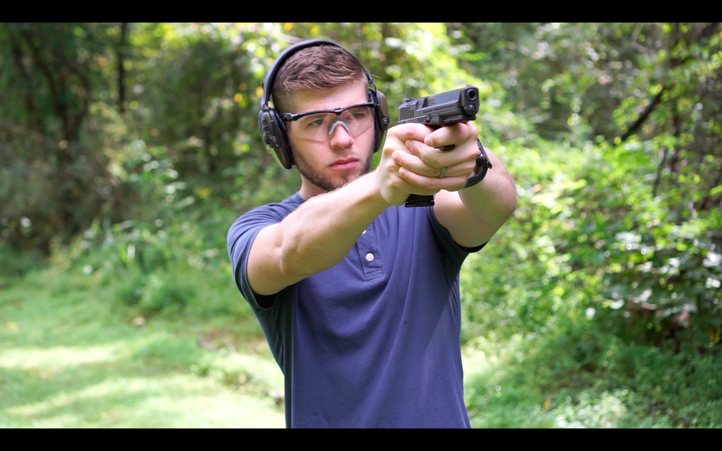 The author Firing a Canik TP9 at the shooting range as part of his review