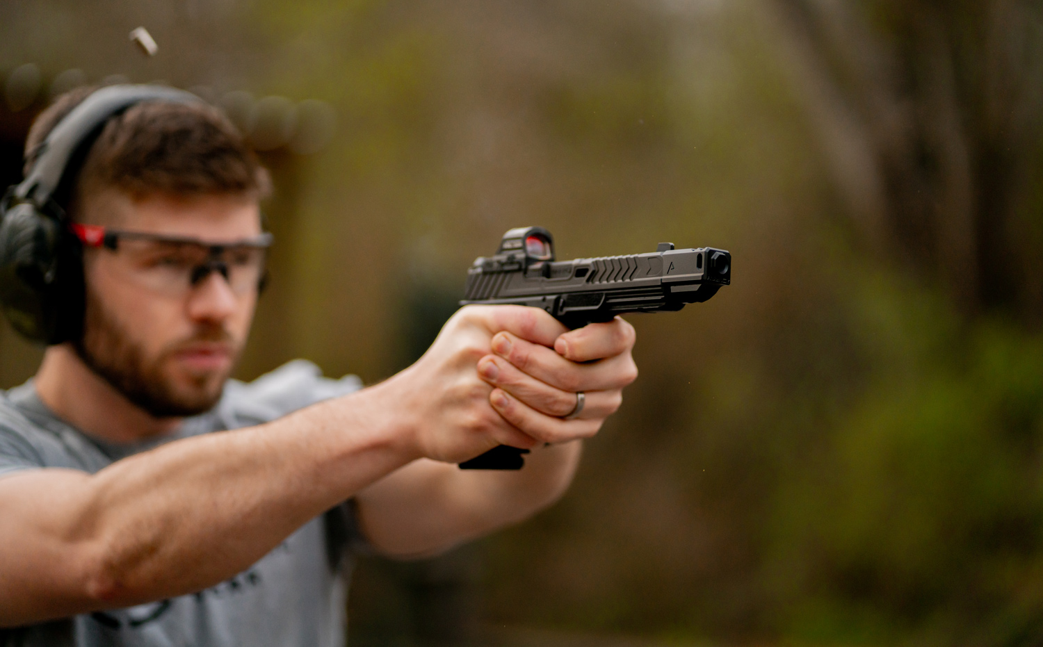The author shooting with a pistol compensator at the range.