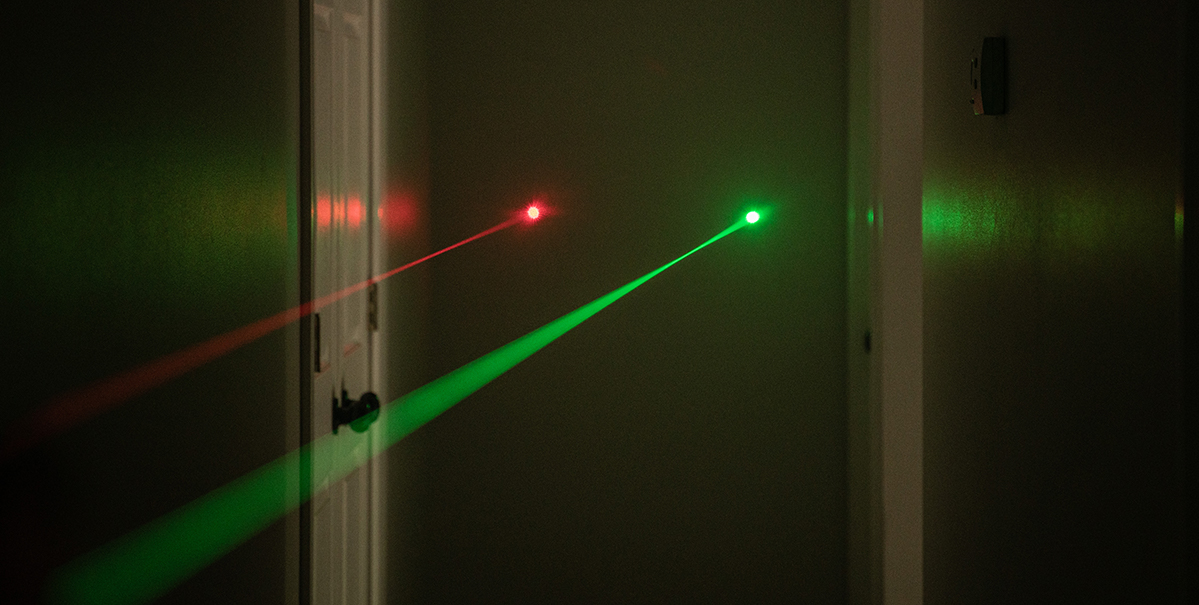 green and red laser sights targeting a wall
